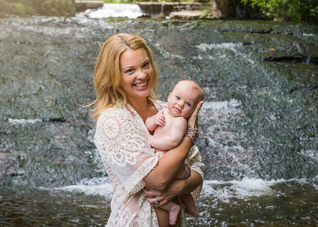 Breastfeeding mom and baby near a waterfall
