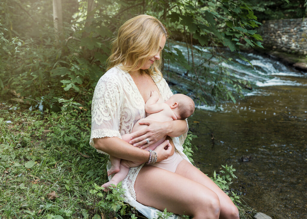 breastfeeding baby with mom near a waterfall
