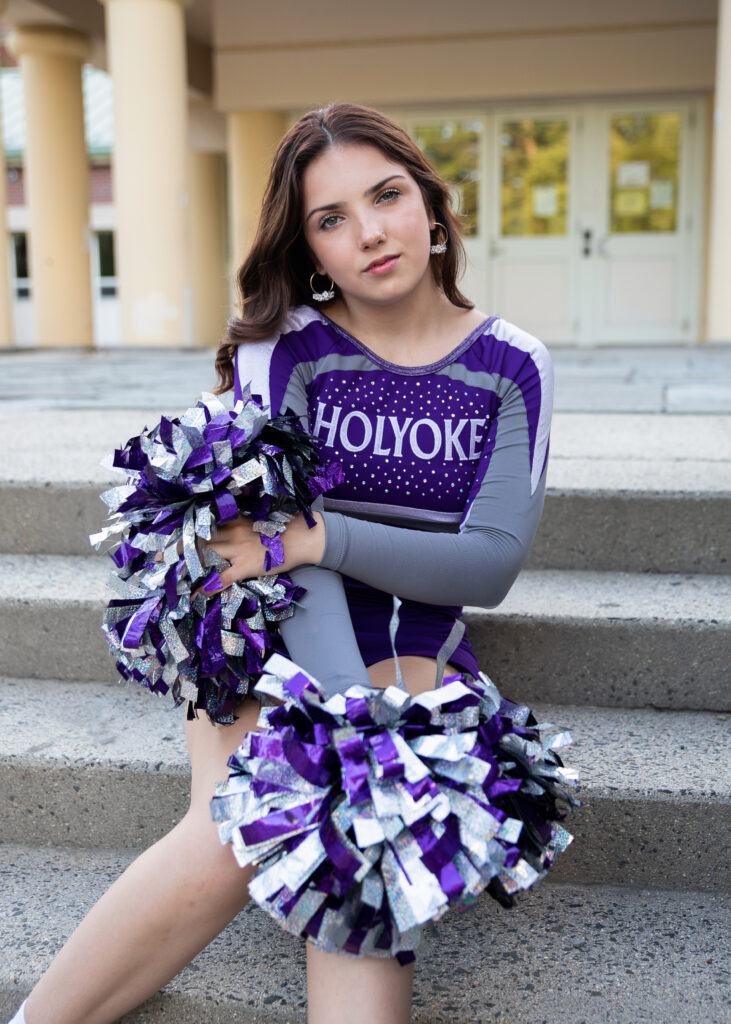 Cheerleader in purple with her pom poms
